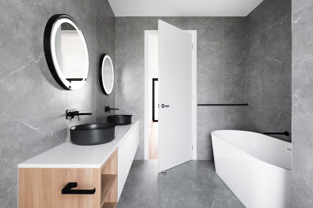 Light bathroom with white vanity under large window
