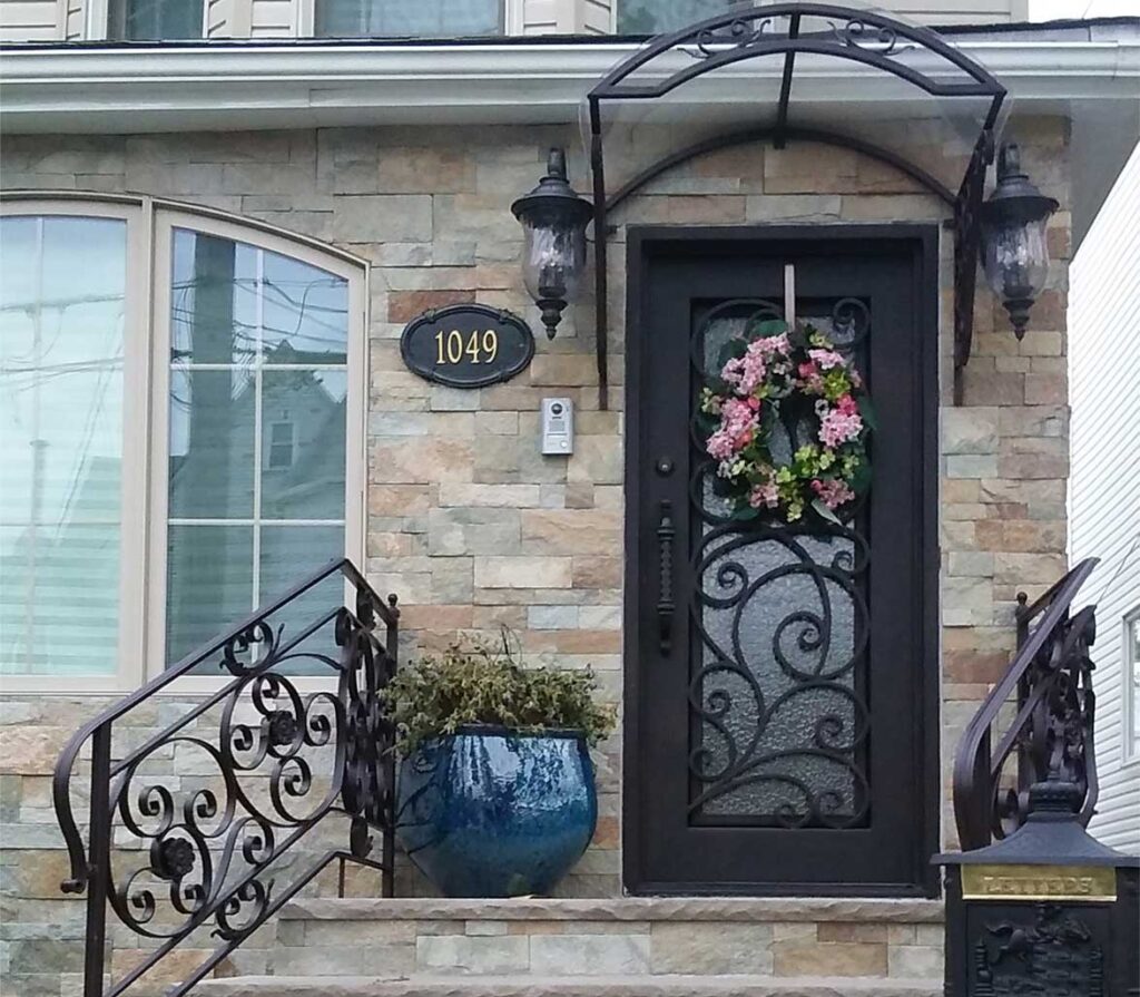 Front door with floral wrought iron grill over clear glass