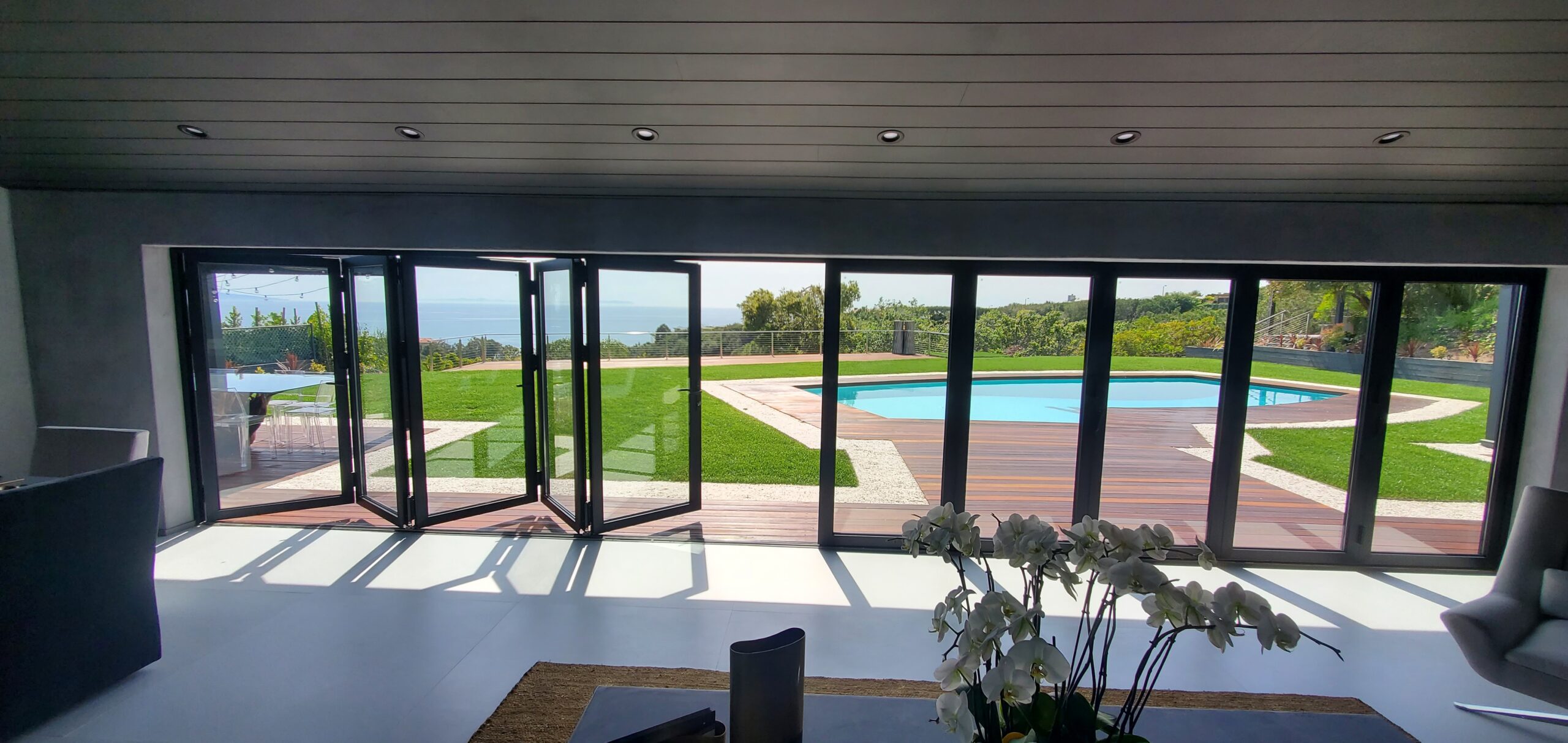 Modern living room with bifold doors fully open to terrace