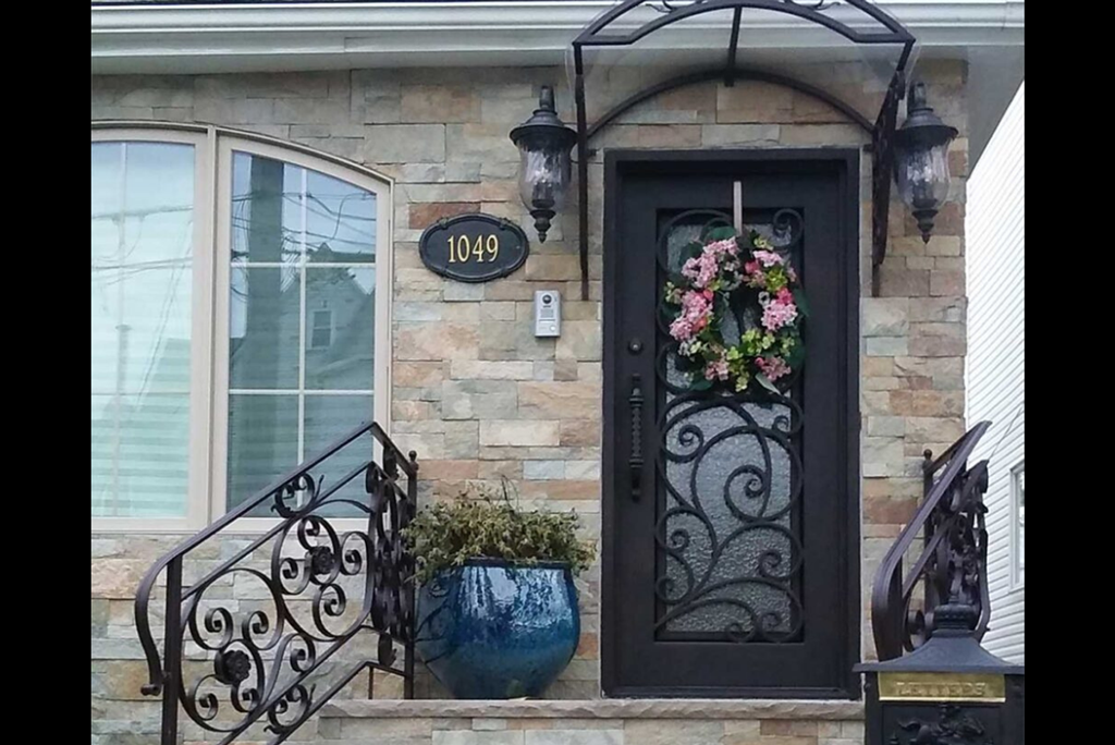 Indoor wine cellar entrance featuring arched wrought-iron glass door and wooden wine racks