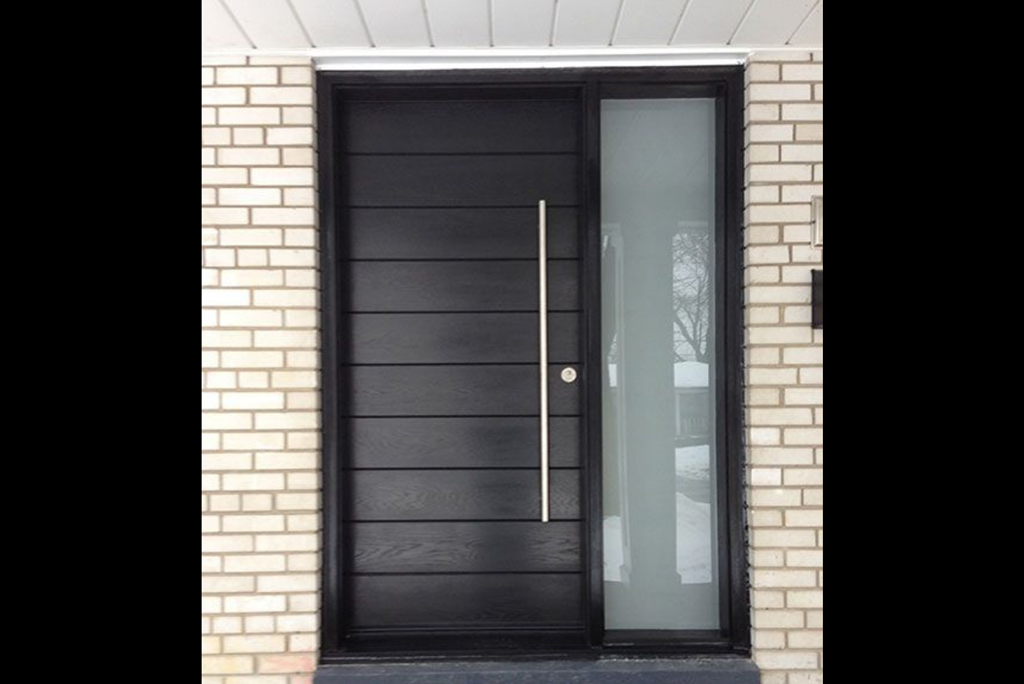 Front exterior view of a home with ornate wrought-iron glass door and brick facade