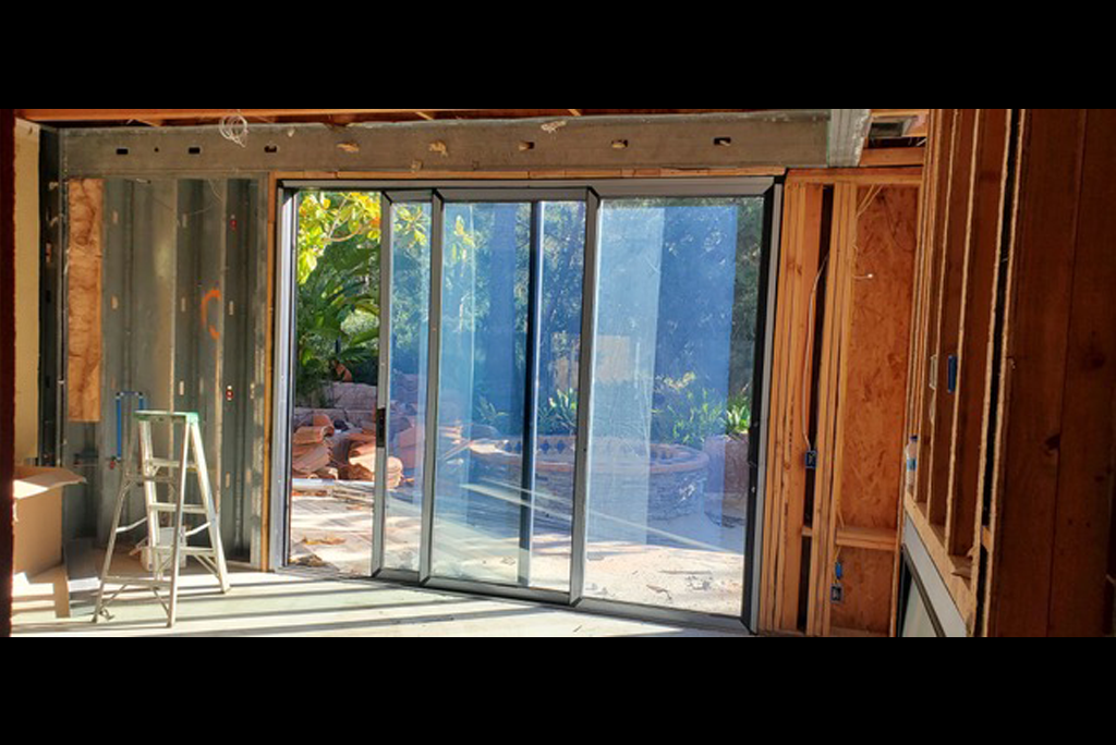 Large sliding glass door in a new build home opening to a sunny garden view.