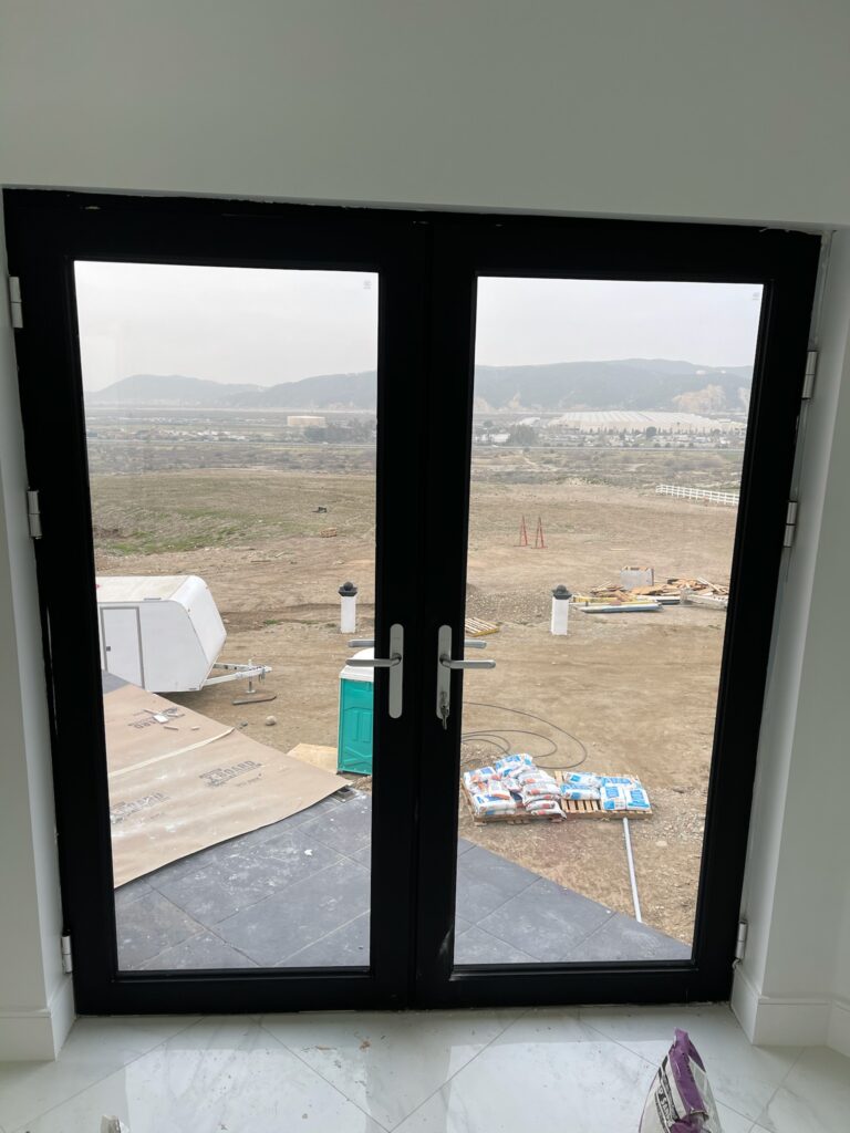 Modern bifold door design with clear glass and black frame.