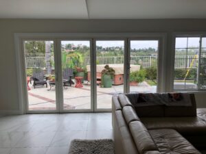 White bi-fold doors opening to a patio with Buddha statue
