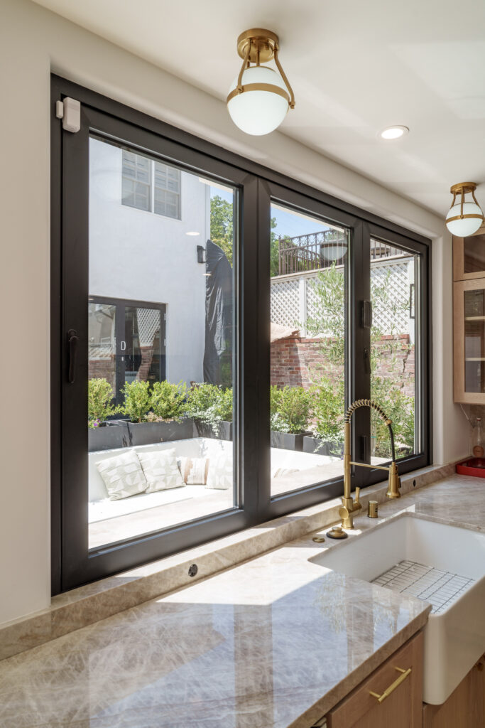 Custom-size bifold window folding open to patio