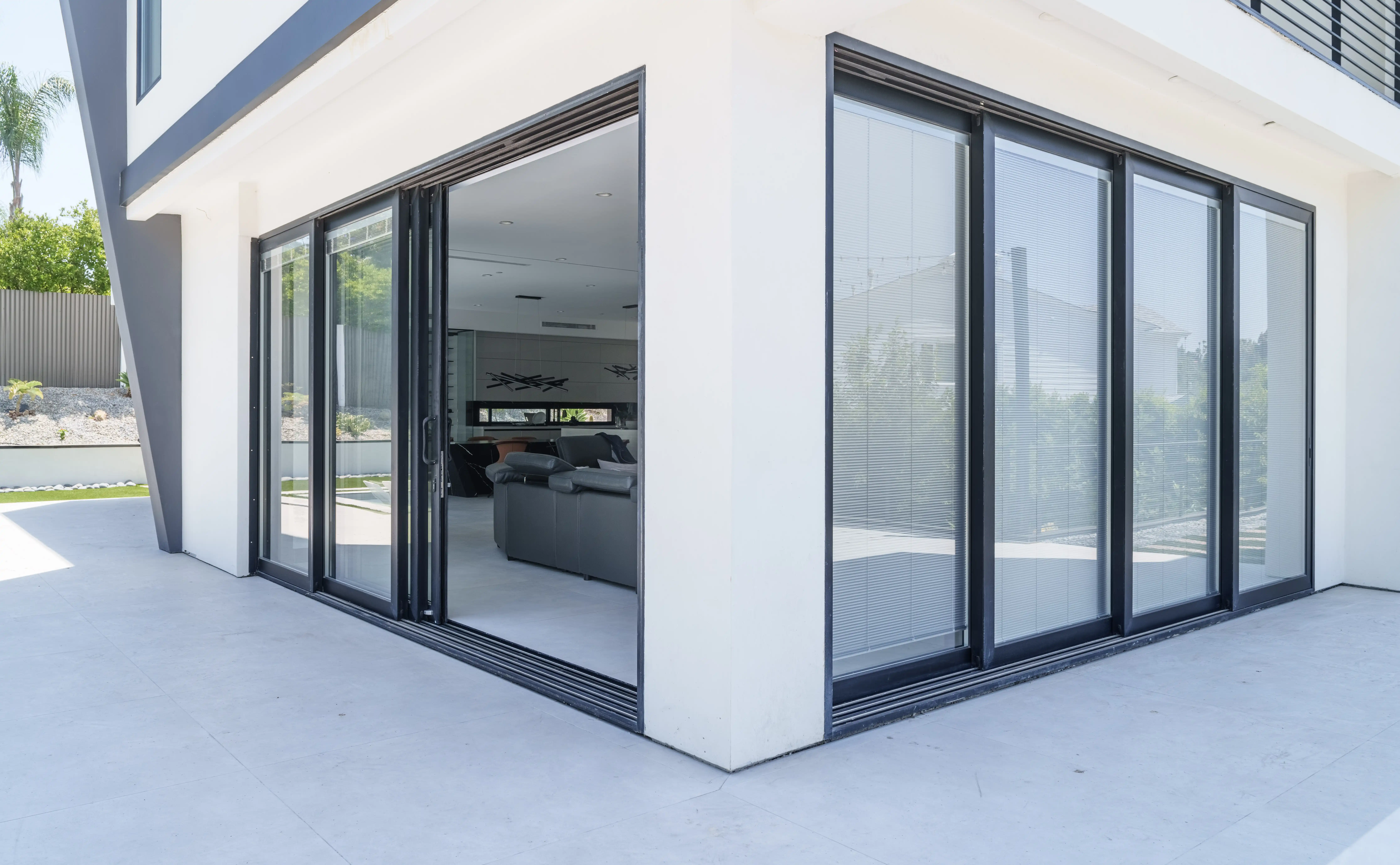 Contemporary space with wide black-framed bifold doors opened to patio